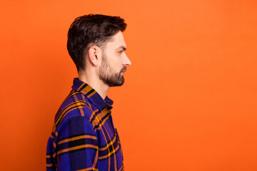 Profile side photo of young handsome brown hair man look empty space focused isolated over orange color background