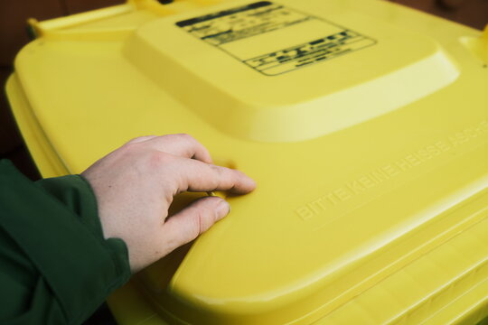 Mann wirft M&uuml;ll in die gelbe Tonne
