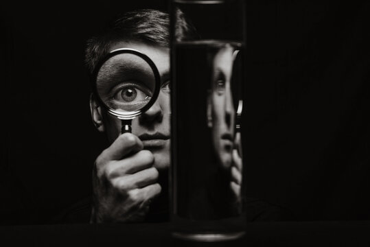 Fototapeta portrait of a strange man looking through a magnifying glass