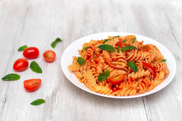 Italian pasta on plate on white wooden background 