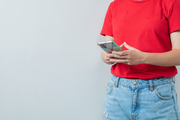 Young girl in red shirt holding a silver smartphone