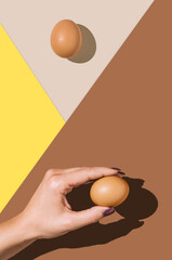 2021 Easter real unique still life composition. Eggs with beautiful woman hand. Flat lay minimal background. - 416703996