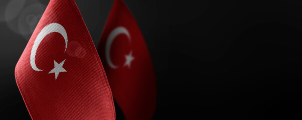 Small national flags of the Turkey on a dark background