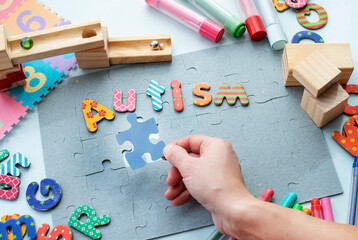 Hand holding a blue puzzle peace. World Autism Awarness Day concept image
