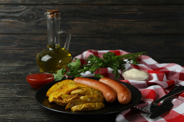 Concept of tasty meal with potato wedges on wooden background