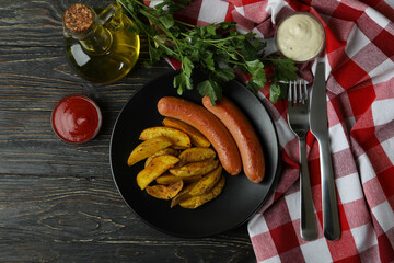 Concept of tasty meal with potato wedges on wooden background