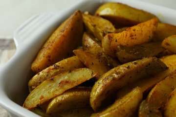 Bowl of tasty potato wedges, close up