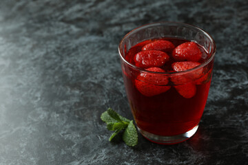 Glass of strawberry jelly on black smokey table