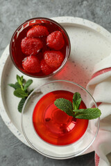 Concept of dessert with red jelly on gray textured table