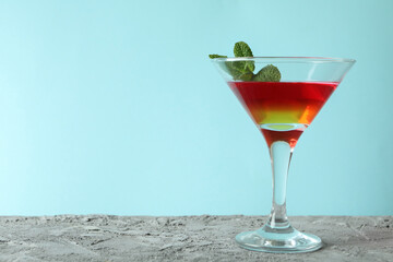 Cocktail glass with strawberry and orange jelly on blue background