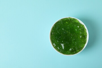 Bowl of kiwi jelly on blue background