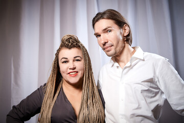 A funny couple of a thin young man and a plump girl with long pigtails. Boy and Girl in love