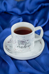 Cup of hot tea on blue cloth