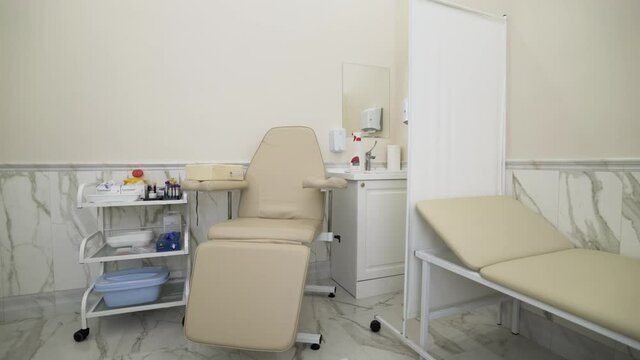 Interior of a medical cabinet at the hospital. Action. Empty medical room with couch and armchair for patients and medical equipment.