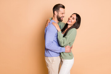 Naklejka premium Photo of young cheerful positive smiling good mood couple laugh hug each other isolated on beige color background