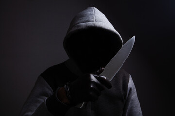 a man holding a large knife threatens
