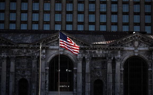 Moody image of USA flag in front of abandoned Michigan Central Train Depot, Detroit, US