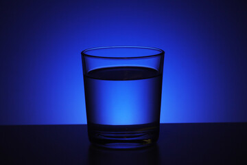 A glass with water at blue background
