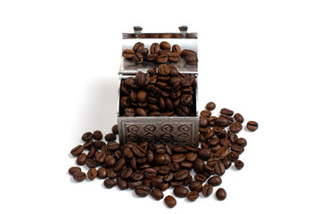Roasted coffee beans in a small metal chest around it. Isolate on a white background. Copspace