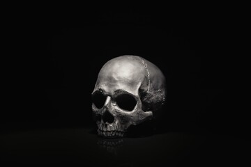 Spooky dark black skull aginast dark background