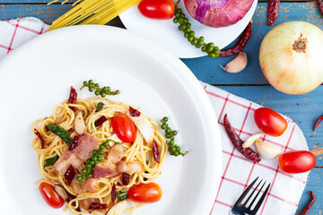 Spicy spaghetti bacon sauce with ingredient homemade on the wooden table.