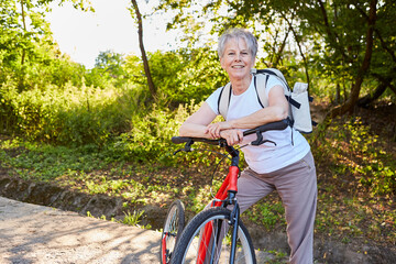 Aktive Seniorin mit Fahrrad oder Tretroller