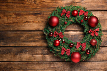 Fototapeta na wymiar Beautiful Christmas wreath on wooden background, top view. Space for text