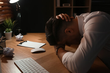 Stressed out businessman at workplace late in evening