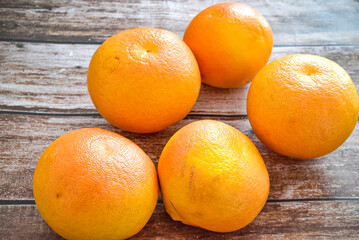 Whole grapefruits on wooden table in kitchen