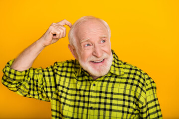 Obraz premium Photo of old man pensioner finger touch head try to remember forget bad memory look empty space isolated over yellow color background