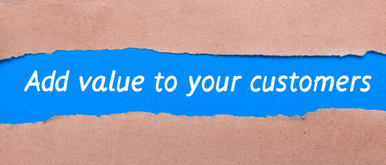 A strip of blue paper with the words ADD VALUE TO YOUR CUSTOMERS between the brown paper. View from above