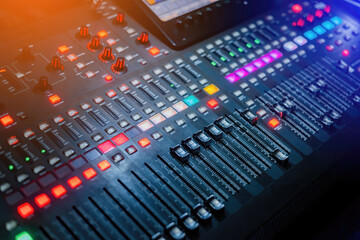 A digital music mixer for mixing music, along with plenty of illuminated buttons in low light...
