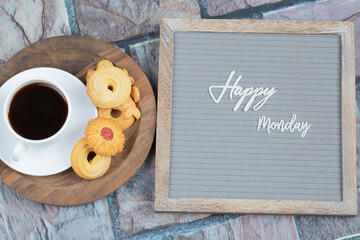 Happy monday poster embedded on grey background with a cup of drink 