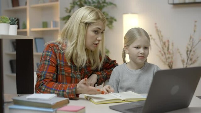 Mother and daughter doing homework  together, working on problem solution