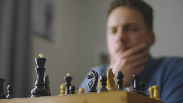 A young handsome guy is thinking about the next move in a difficult game