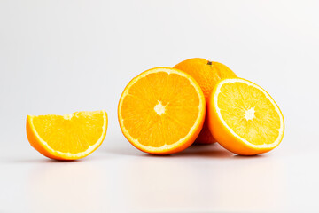 An orange in fruit with full and a half showing in isolated background.