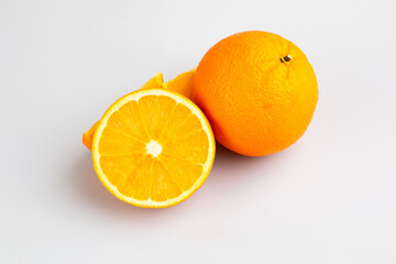An orange in fruit with full and a half showing in isolated background.