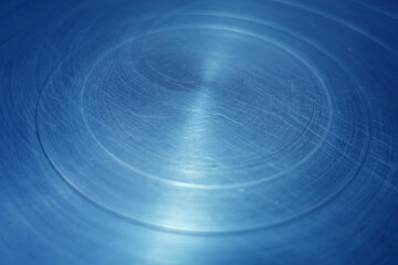 Scratched blue toned round metal surface