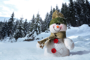 Cute small decorative snowman outdoors on sunny day, space for text