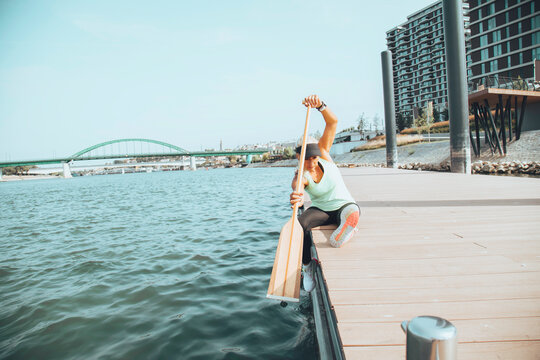 Woman in sportswear doing exercises near the river. Healthy lifestyle concept.