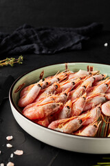 shrimp in a plate on black textured background
