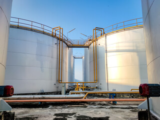 Obraz premium Fuel storage tank oil. Large white industrial for tank oil. Crude oil export factory industry And storage tank . industrial pipes 