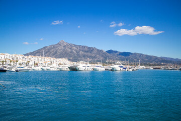 View of Puerto Banus marina with boats and white houses in Marbella town at sunrise, Andalusia, Spain