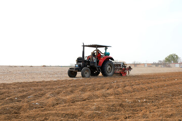 Obraz premium Farmers drive agricultural machinery to plant sweet potatoes in the fields.