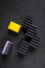 dark violet and black sponges and a yellow sponge on black background