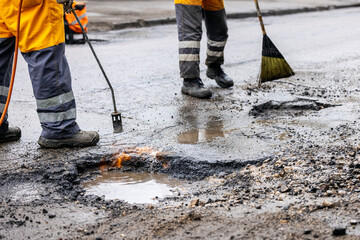 pothole repair - maintenance service workers working on the road - obrazy, fototapety, plakaty