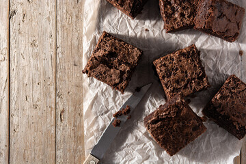 Homemade pieces of brownies on wooden table. Top view