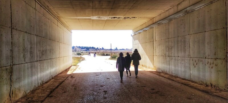 People Walking Through The Tunnel