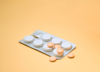 Various medical pills on orange background