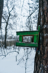 Wooden bird feeder in the forest. Winter snowy forest. Feeder in the tree. Birdhouse
